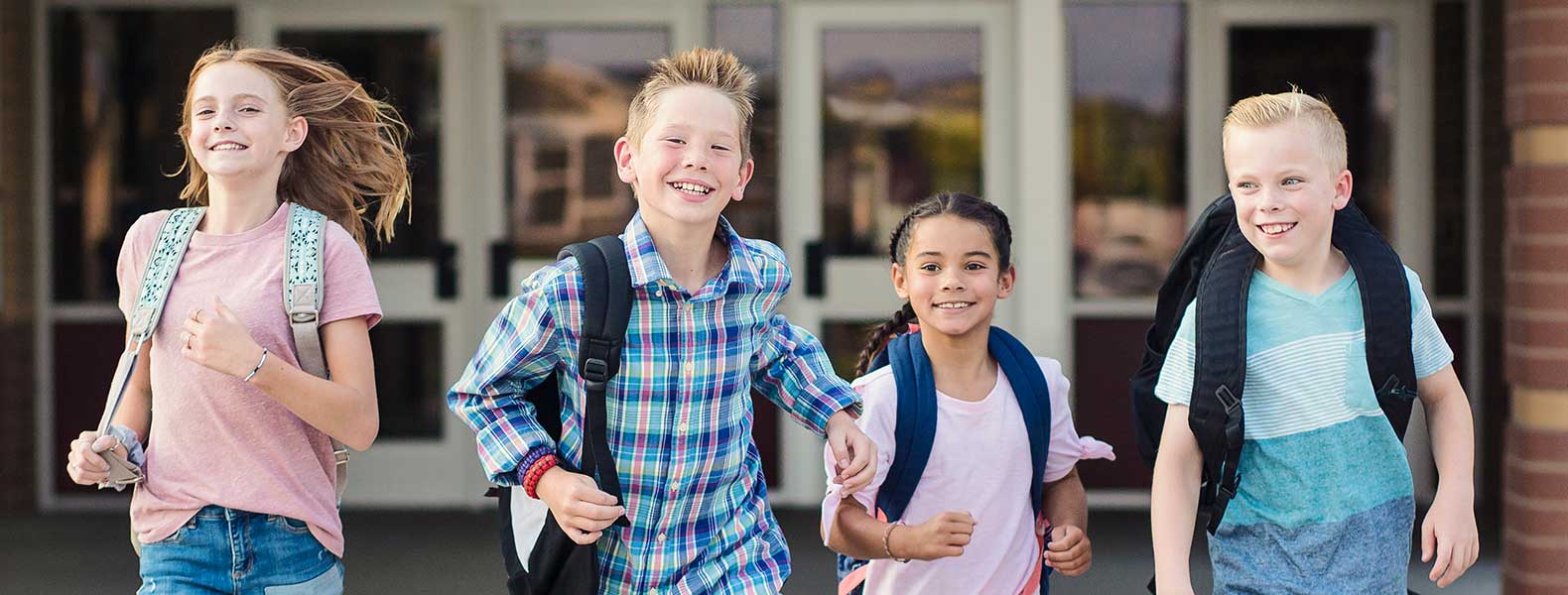Smiling students running toward camera