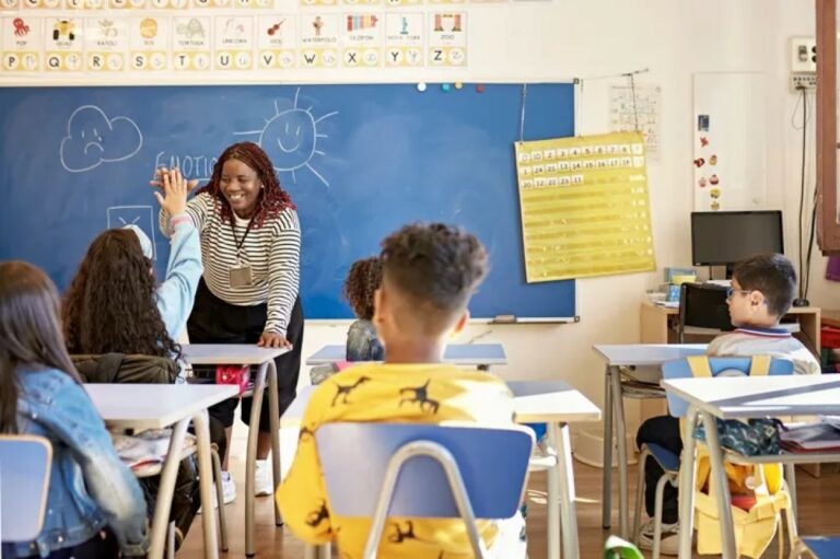 teacher giving a student a high five.