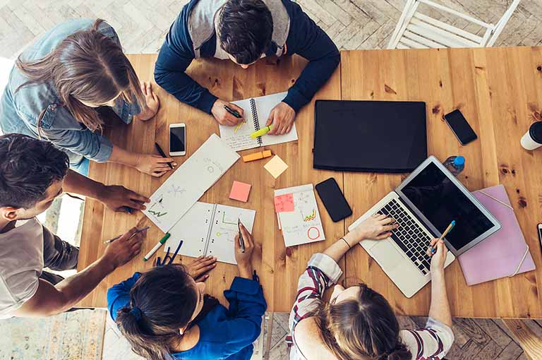 Bird's eye view of people working around a table.