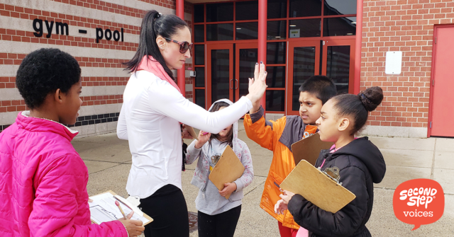 Teacher giving high-fives to kids